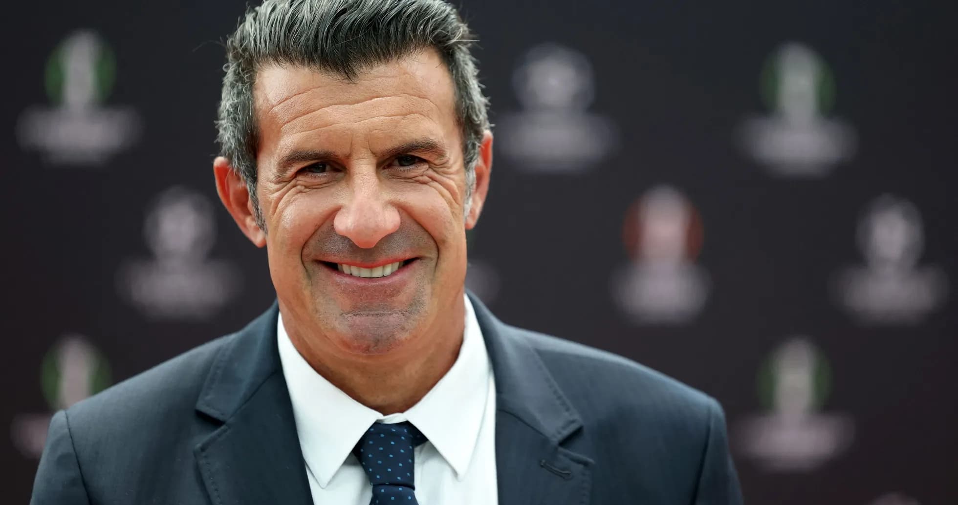 Hombre sonriendo en evento de fútbol