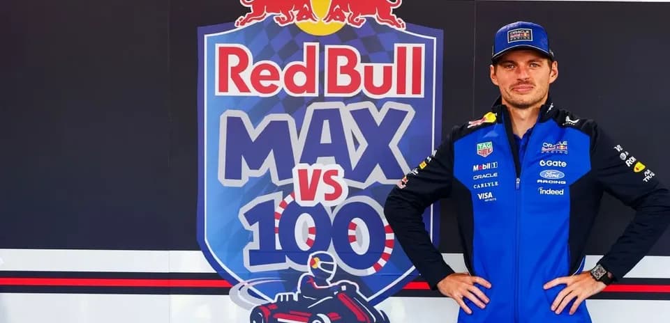 Piloto de Fórmula 1 posando frente a cartel Red Bull