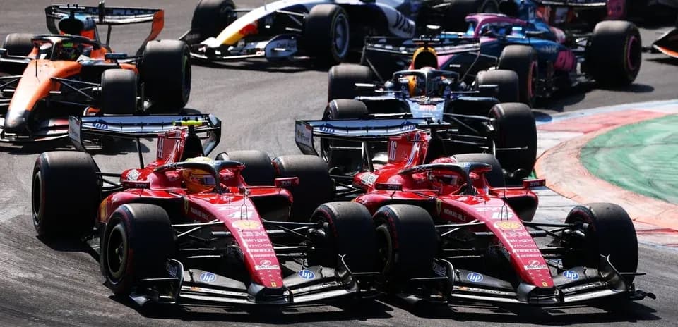 Dos coches de Ferrari compitiendo en curva durante carrera