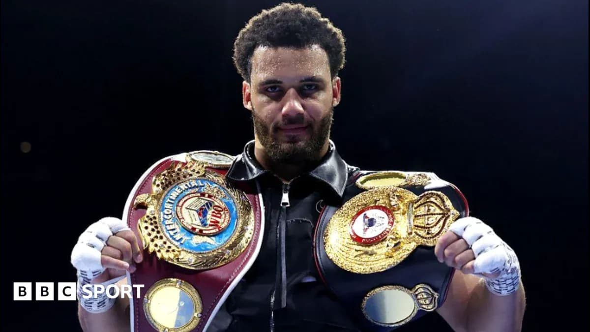 Boxeador sosteniendo cinturones de campeón en el ring