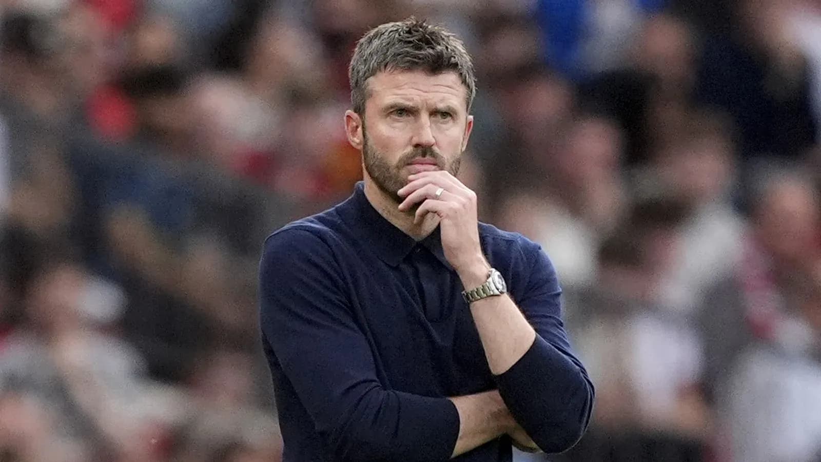 Entrenador observando el partido con expresión pensativa