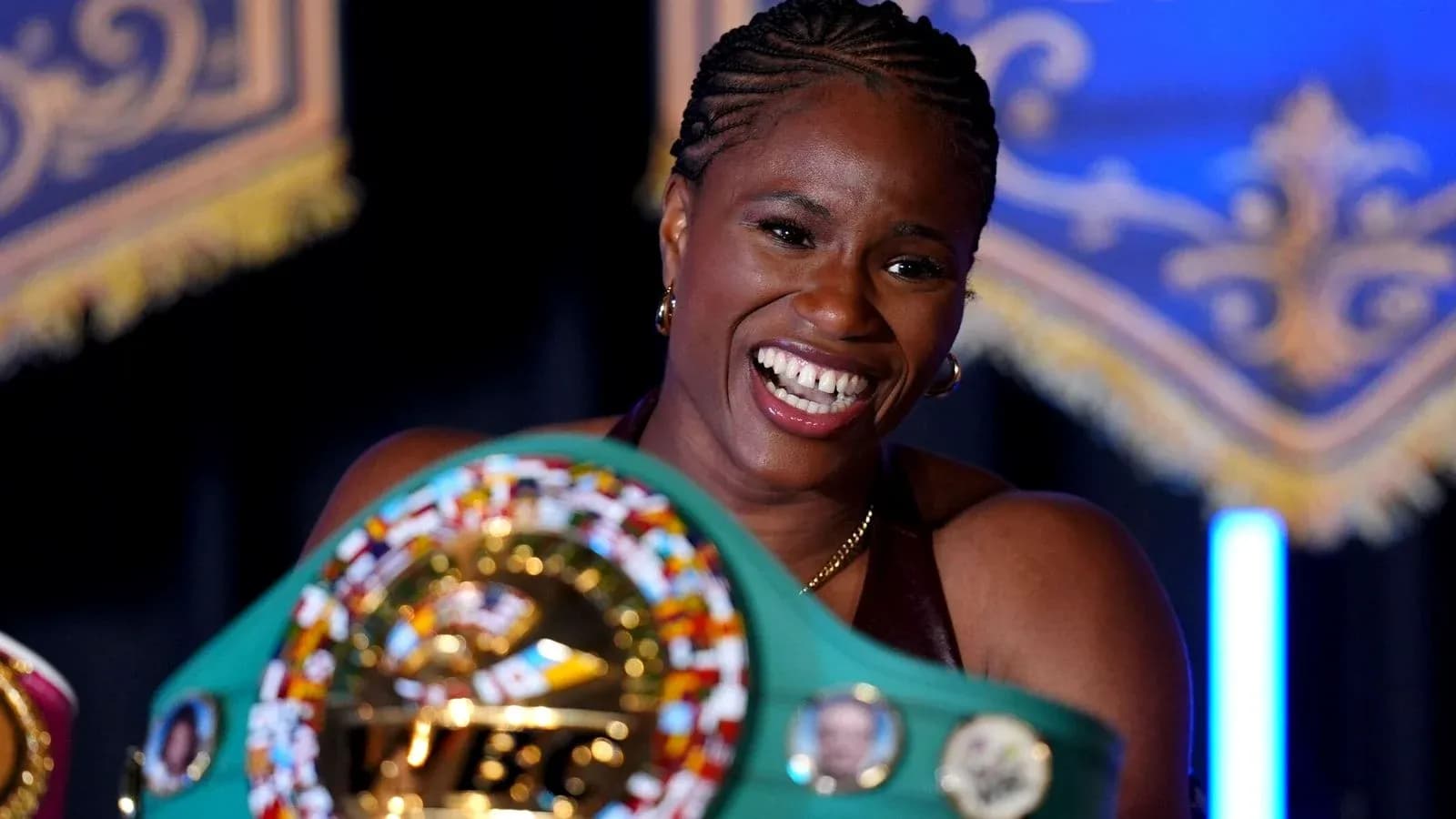Boxeadora sosteniendo su cinturón de campeona sonriente