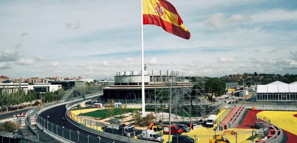 Circuito con bandera de España y vehículos de construcción