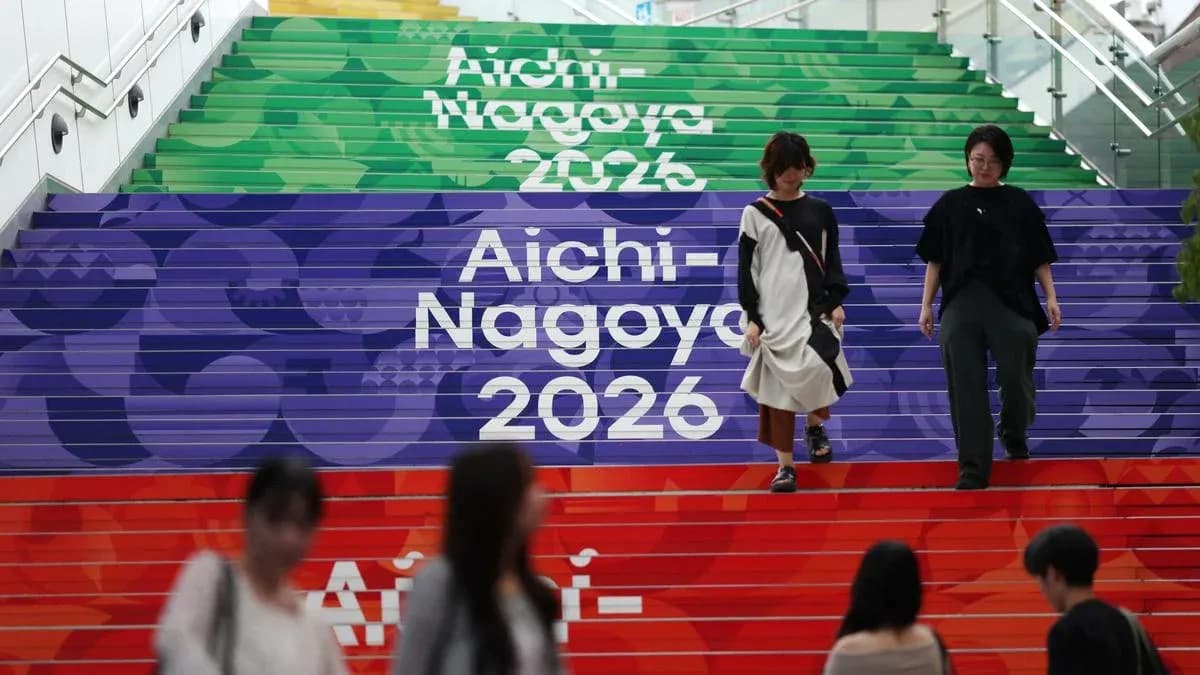 Escalera decorada con Aichi-Nagoya 2026 y personas caminando