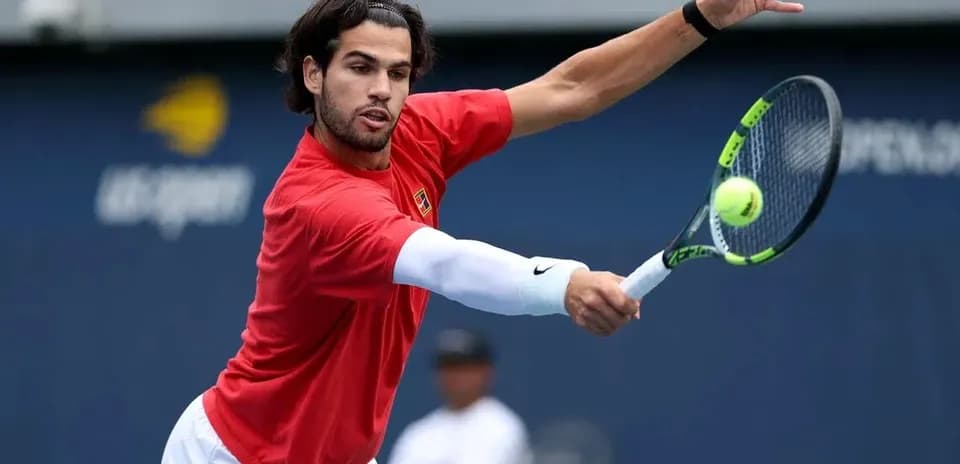 Jugador de tenis golpeando la pelota en entrenamiento