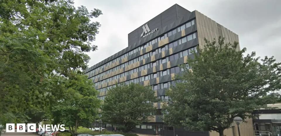 Edificio Marriott rodeado de árboles y coches