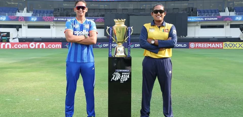 Capitanas de cricket posando junto al trofeo