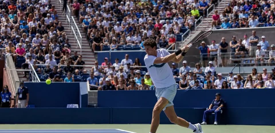 Jugador de tenis golpeando la pelota en un partido