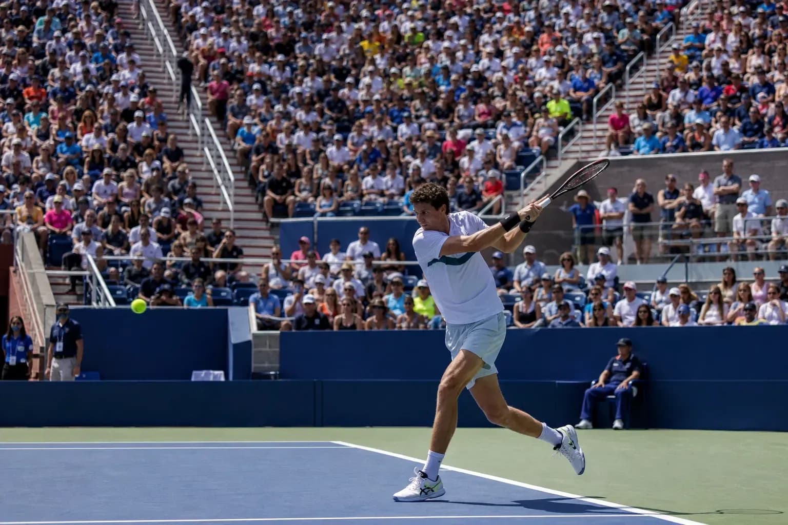 Jugador de tenis golpeando la pelota en un partido