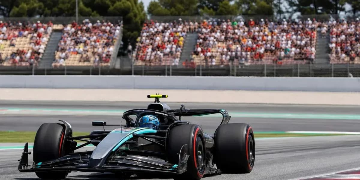 Coche de Fórmula 1 en pista con público al fondo