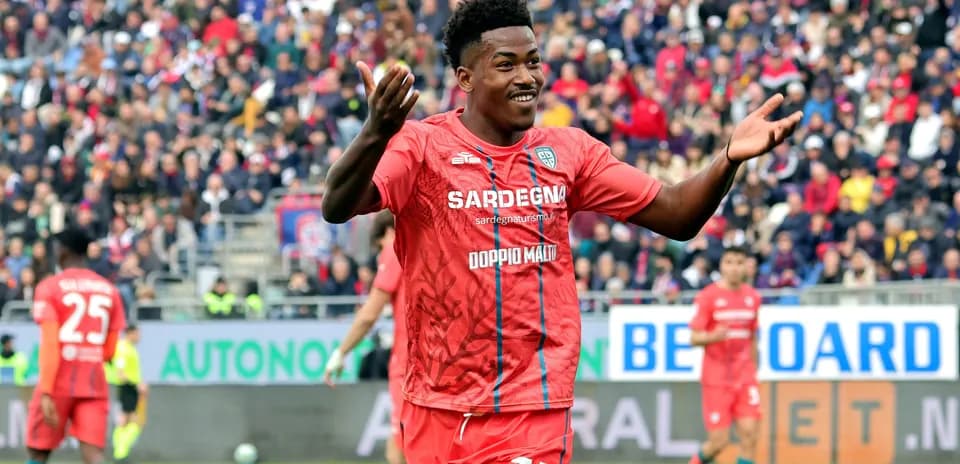 Jugador celebrando en partido con afición al fondo