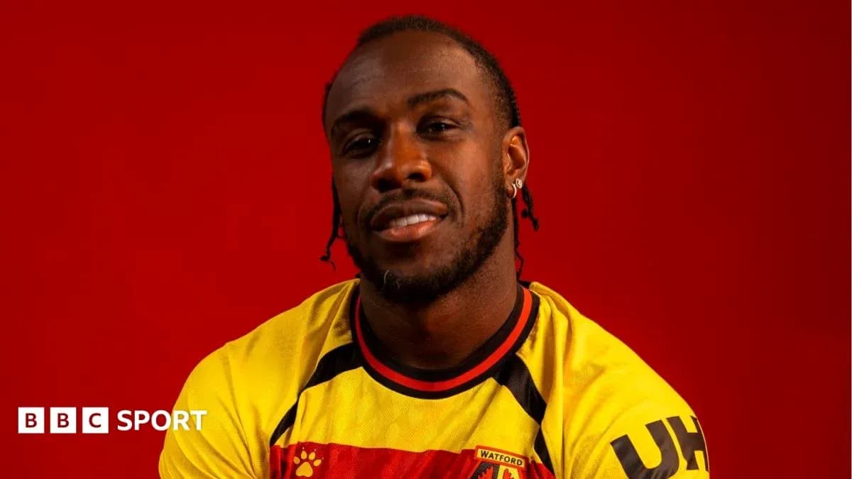 Jugador posando en camiseta de Watford con fondo rojo