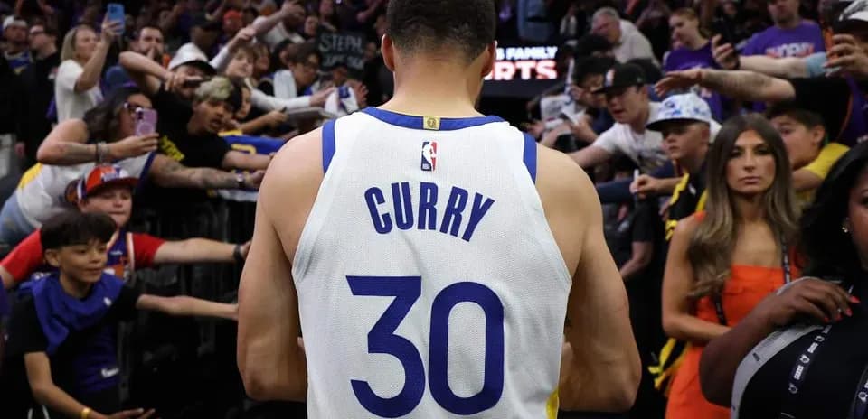 Jugador de baloncesto saliendo del campo rodeado de aficionados