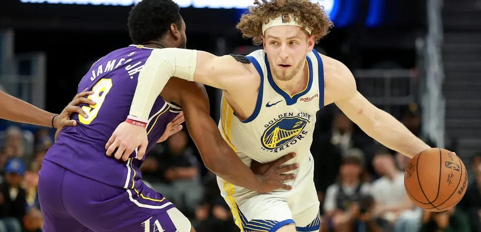 Jugador de Warriors driblando mientras es defendido