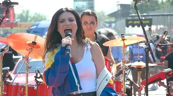Cantante actuando en un evento con banda