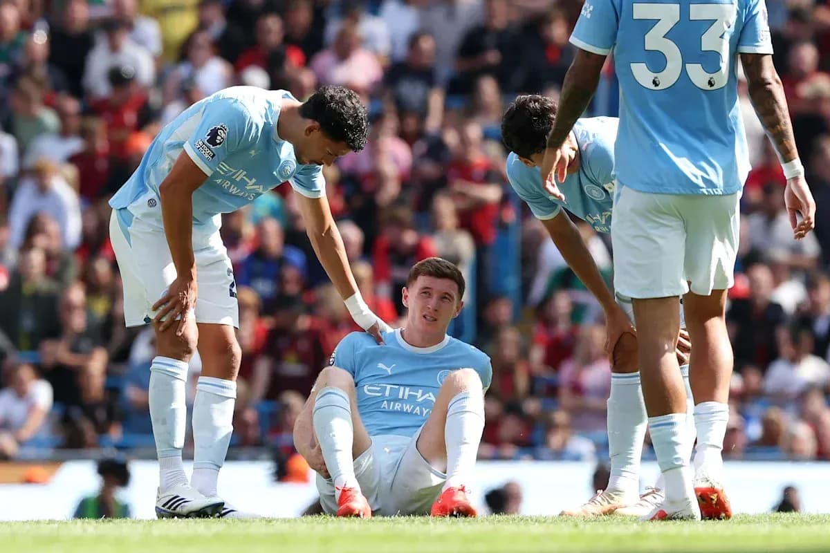 Jugador de Manchester City sentado con compañeros preocupados