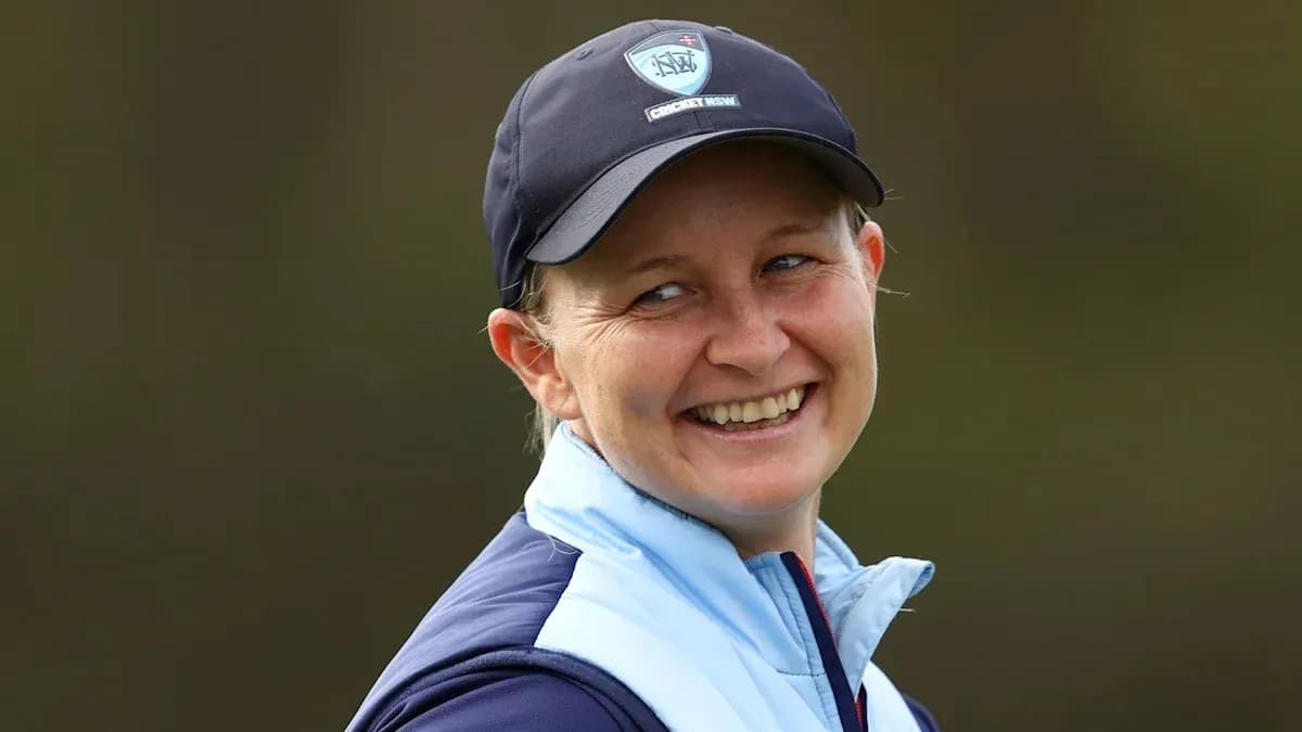 Jugadora de cricket sonriendo en el campo