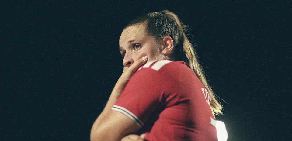 Jugadora con camiseta roja en el campo de fútbol