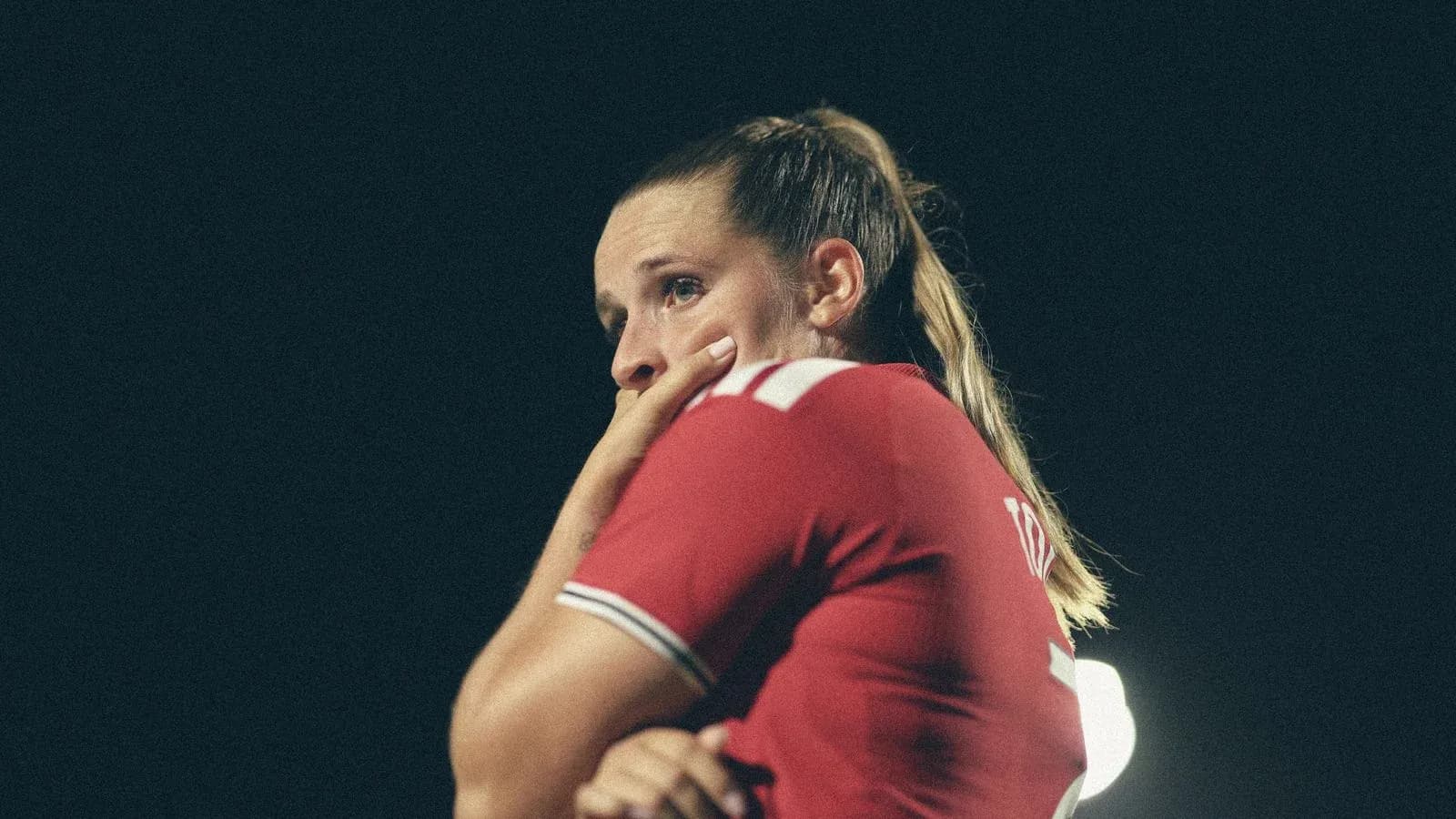 Jugadora con camiseta roja en el campo de fútbol