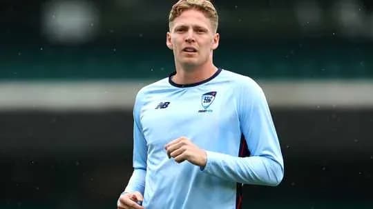 Jugador entrenando con camiseta azul en el campo
