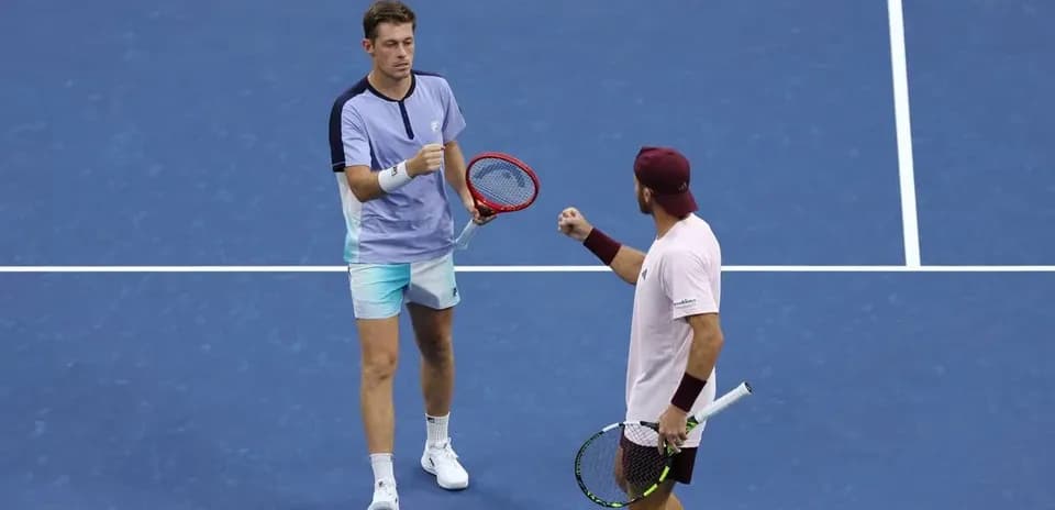 Jugadores celebrando en una cancha de tenis