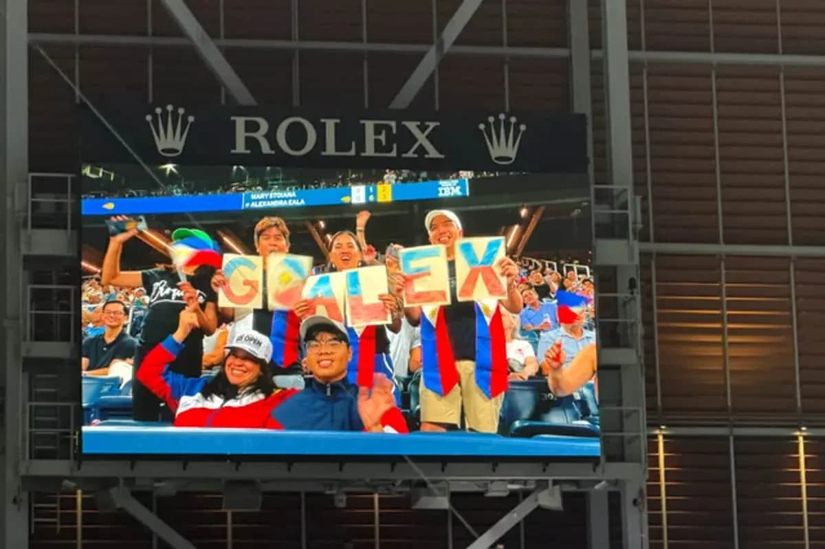 Aficionados sosteniendo carteles que dicen 'GO ALEX'