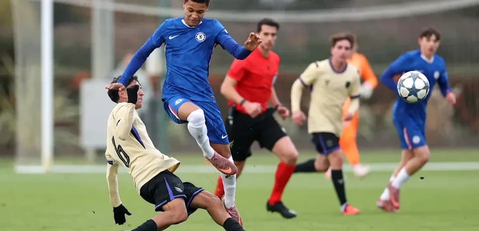 Jugador de Chelsea saltando sobre adversario caído