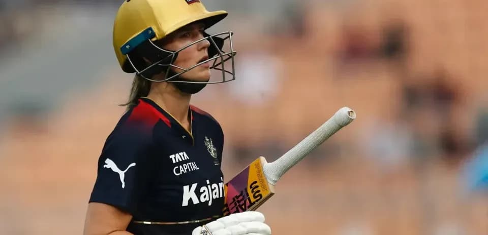 Jugadora de cricket con casco y bate en el campo