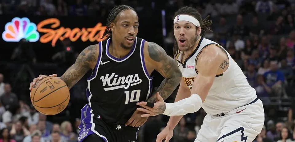 Jugador de los Kings driblando mientras es defendido