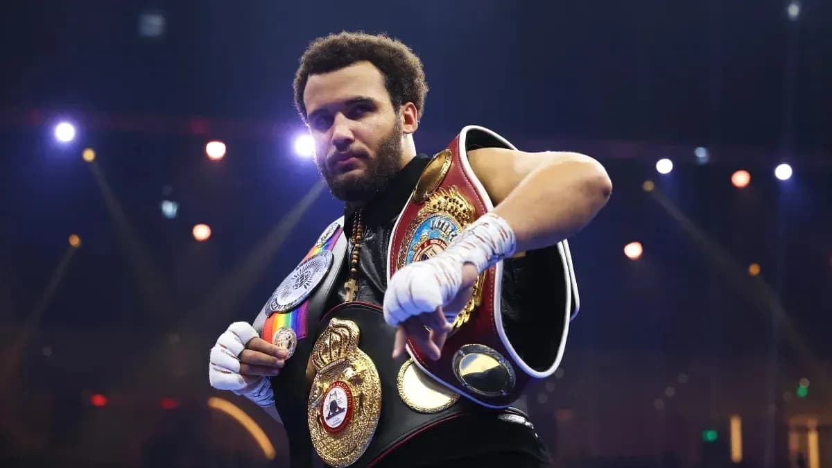 Boxeador mostrando sus cinturones de campeón