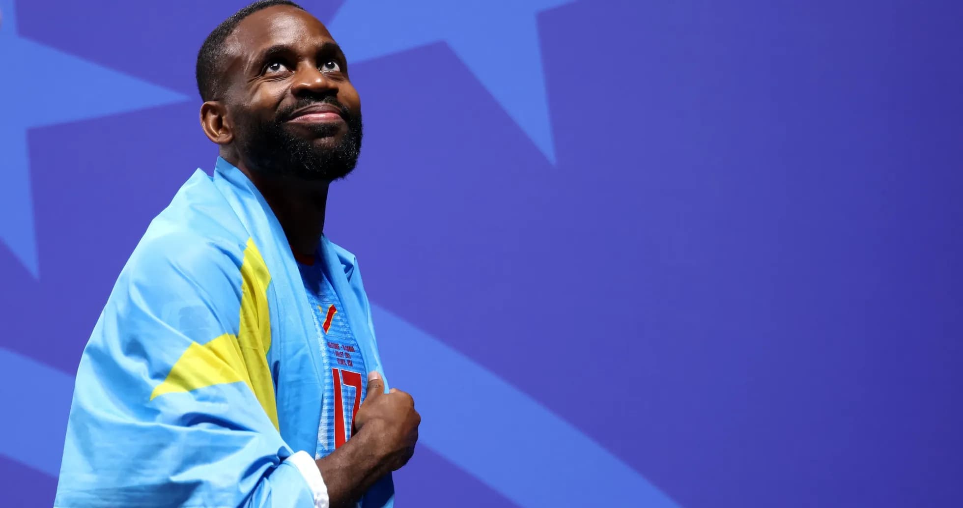 Atleta envuelto en bandera sonriendo en el escenario
