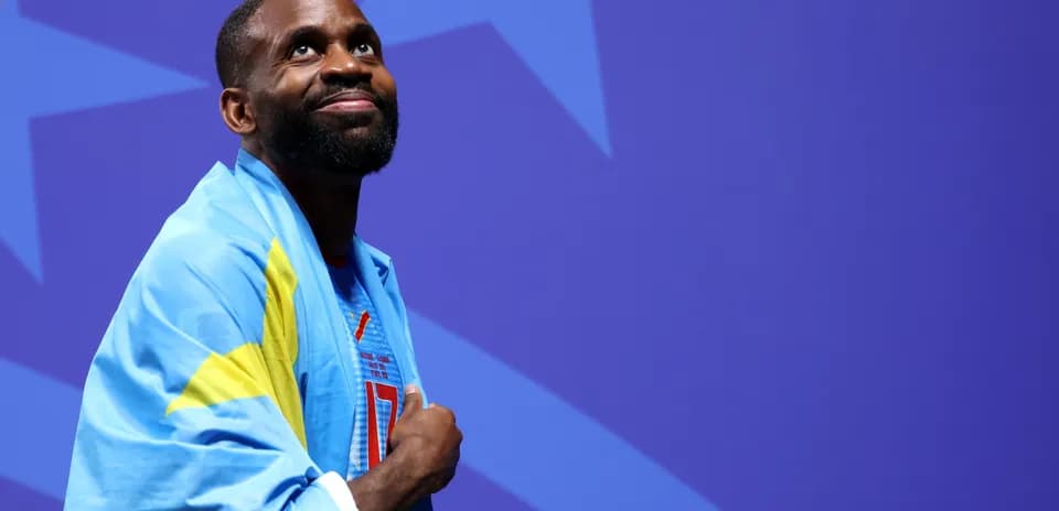 Atleta envuelto en bandera sonriendo en el escenario