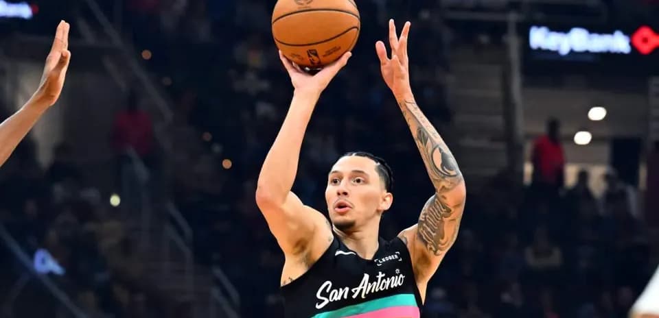 Jugador lanzando un balón de baloncesto en partido