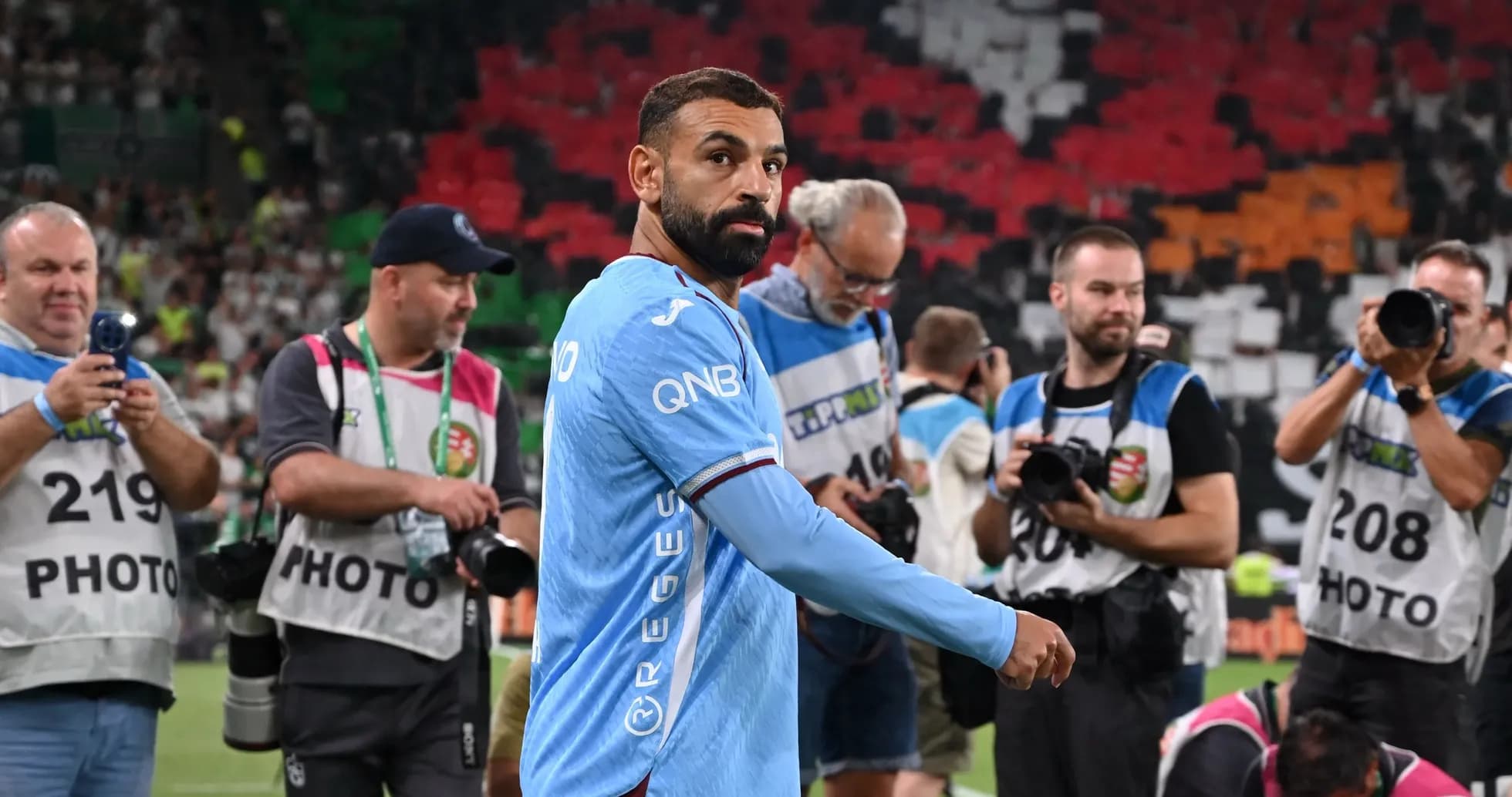 Jugador saliendo del campo rodeado de fotógrafos
