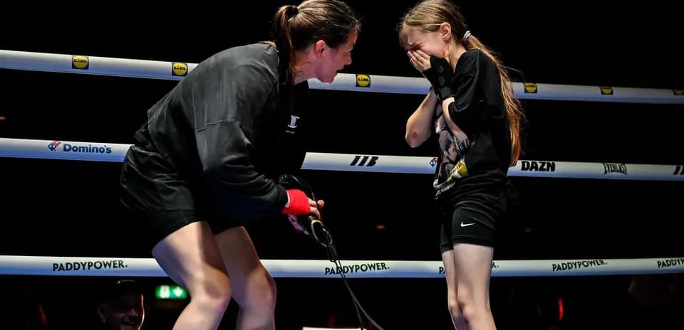 Boxeadora hablando con una niña en el ring