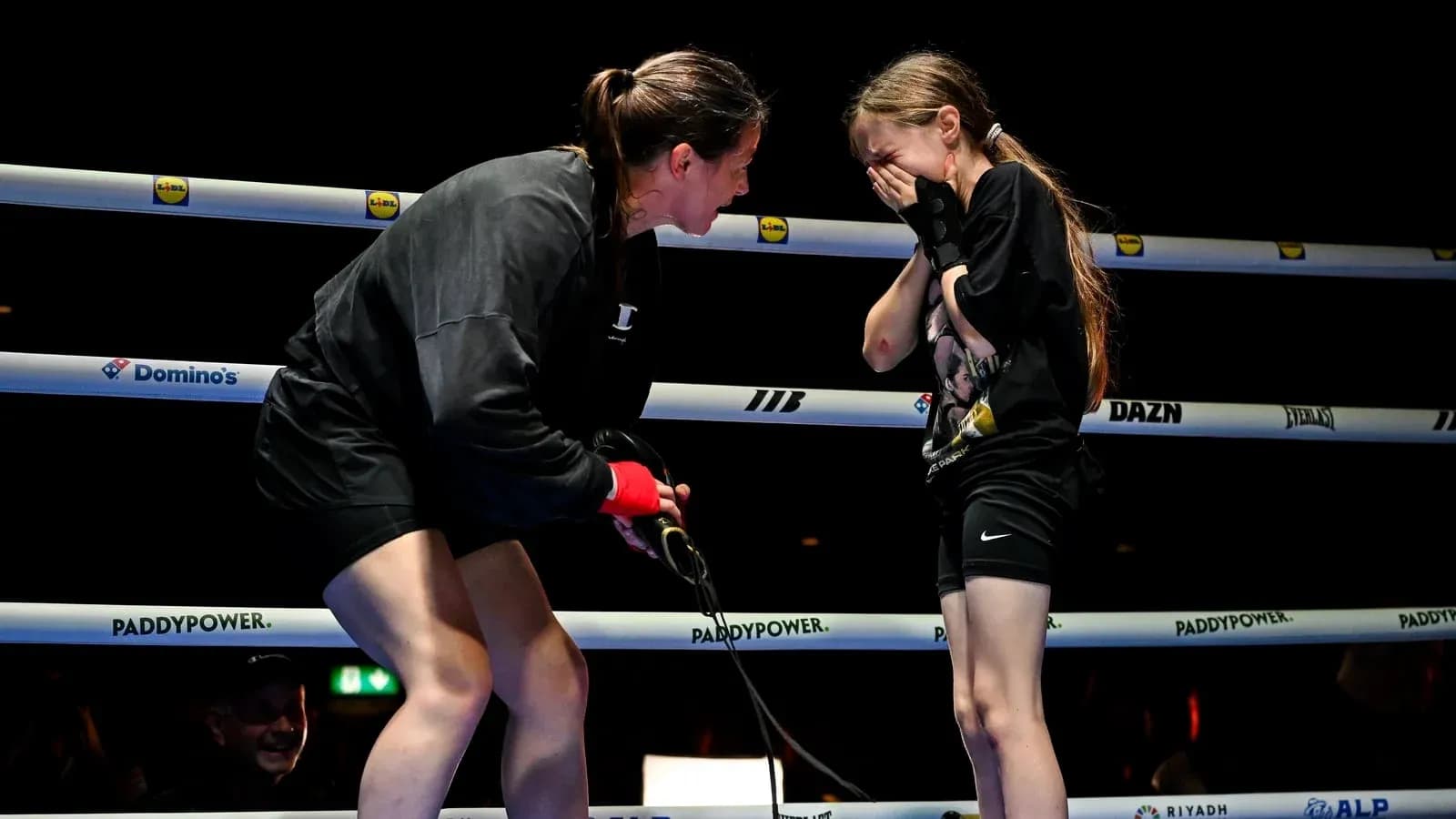 Boxeadora hablando con una niña en el ring