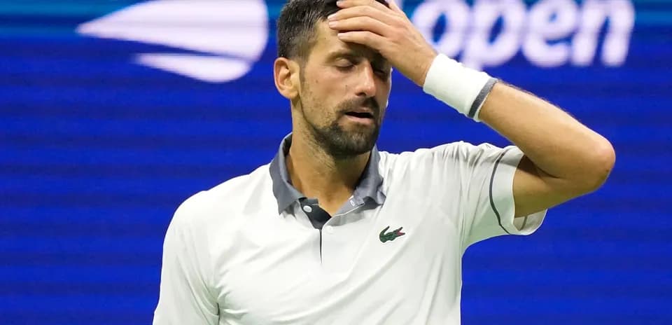 Jugador de tenis con mano en la frente durante partido