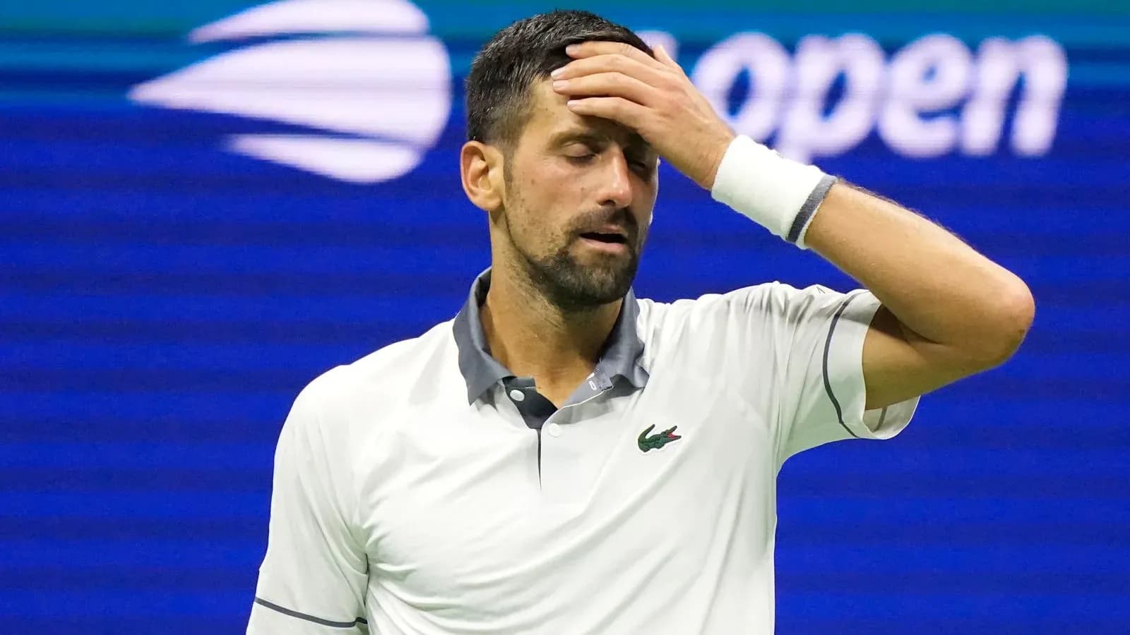 Jugador de tenis con mano en la frente durante partido