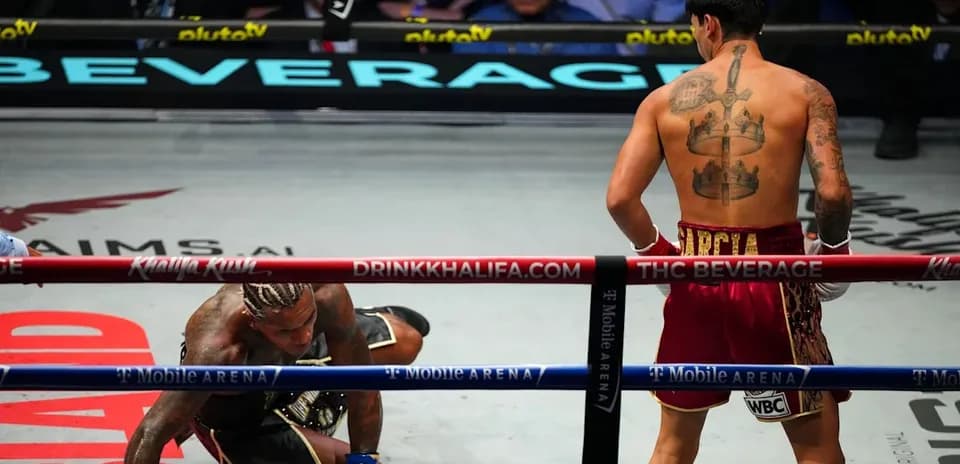 Boxeador en el suelo y otro de pie en el ring