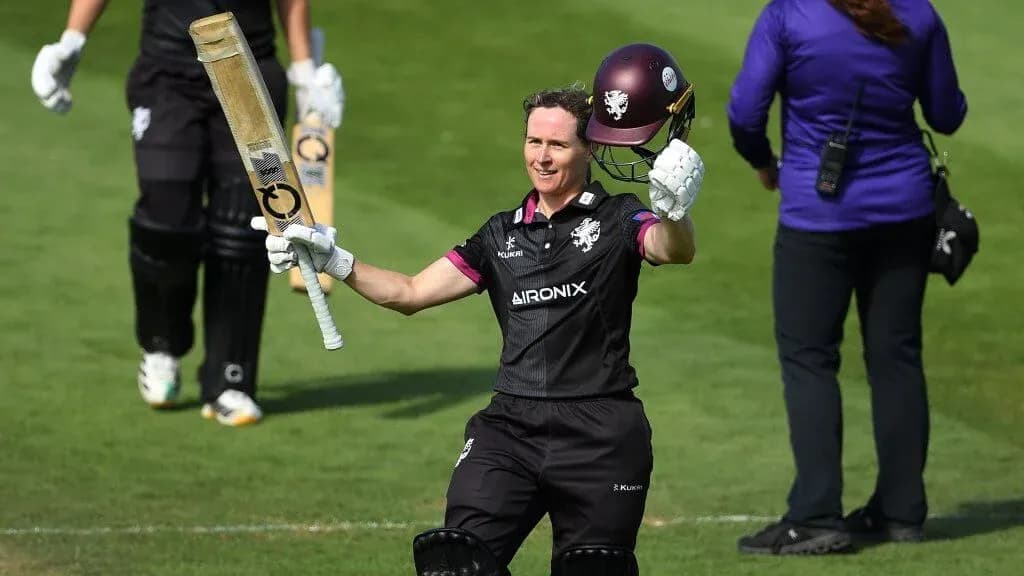 Jugador de cricket levantando su bate tras anotar