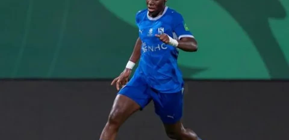 Jugador corriendo con balón en el campo de fútbol