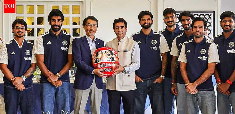 Equipo de cricket posando con una figura Daruma