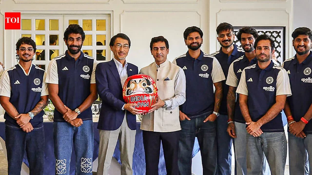 Equipo de cricket posando con una figura Daruma