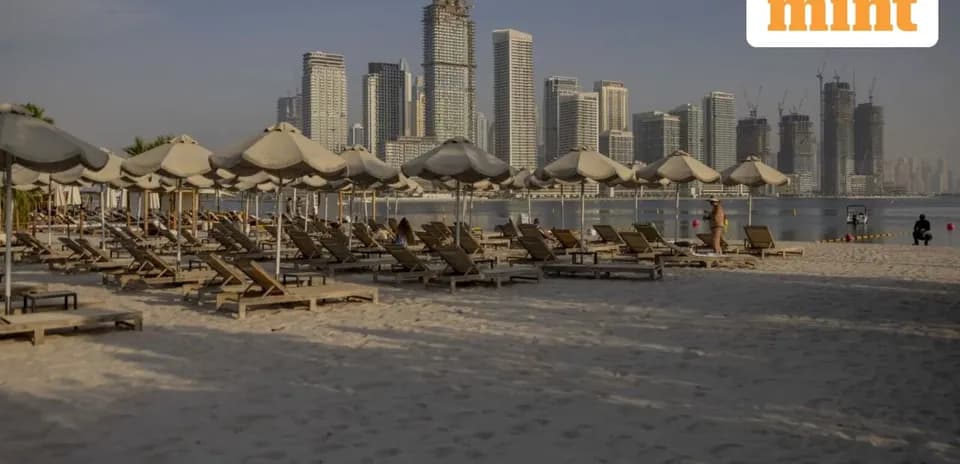 Playa con tumbonas y edificios de fondo