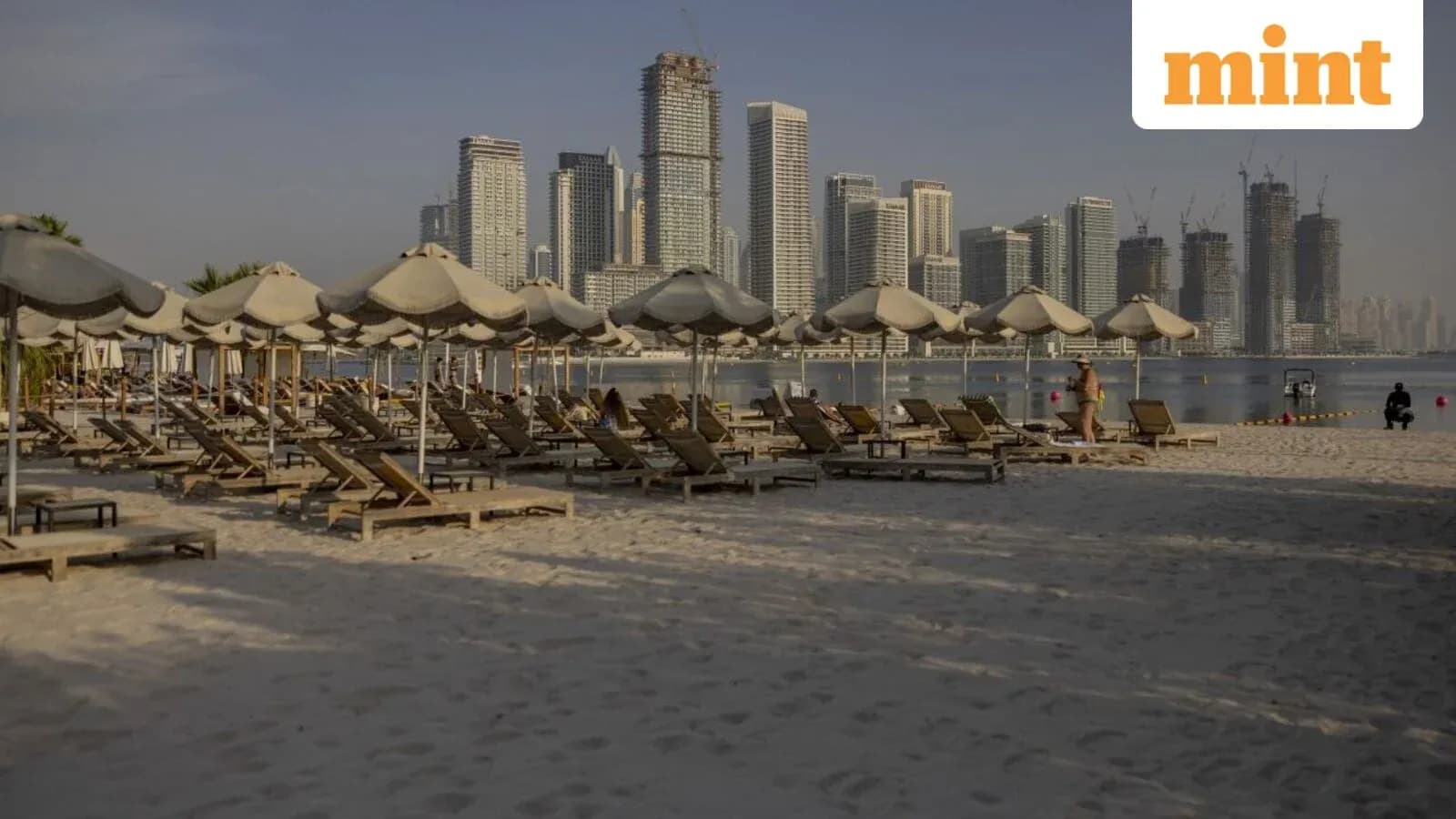 Playa con tumbonas y edificios de fondo