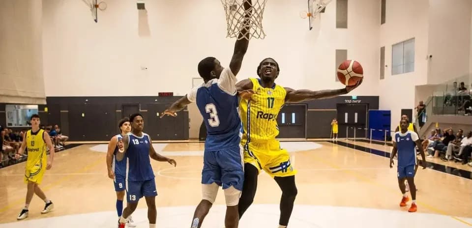Jugador realizando una volcada en partido de baloncesto