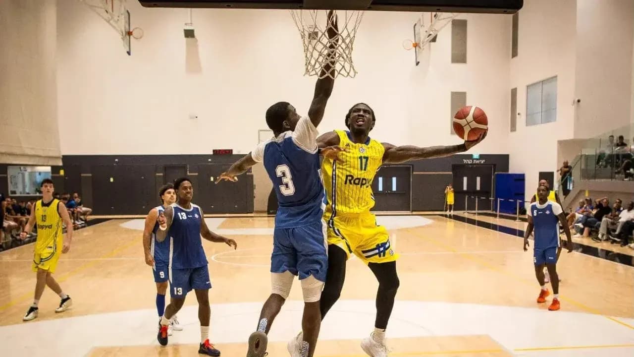 Jugador realizando una volcada en partido de baloncesto