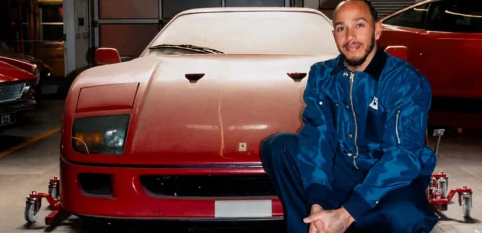 Hombre agachado junto a un Ferrari rojo en taller