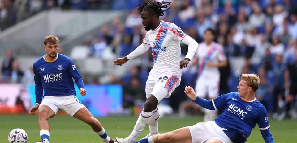 Jugador de Crystal Palace driblando a dos rivales de Everton