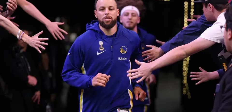 Stephen Curry corriendo hacia la cancha entre aficionados